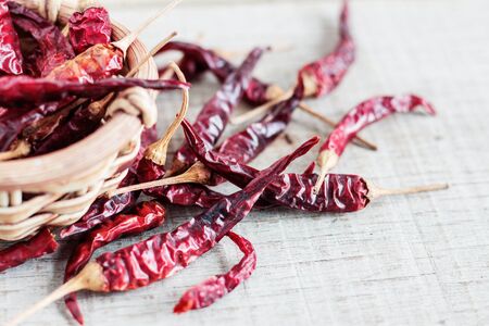 dried chilli on wooden floor with a white background.の写真素材