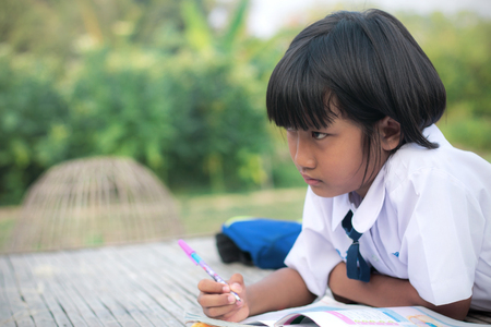 Asian girl of student dress doing homework.の写真素材