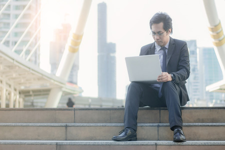 Businessman sitting on a stairs in the cityの写真素材