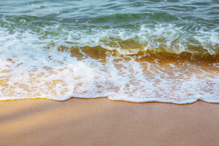 Sand beach and waves at the sea.