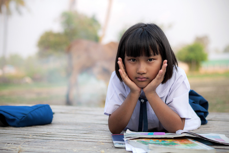 School girl with homework in the countryside of Thailand.の写真素材