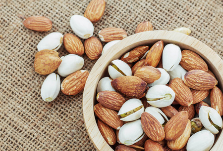 Almond in wooden bowl on a sack.の写真素材