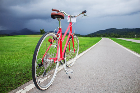 Red bike on road in the park.の写真素材