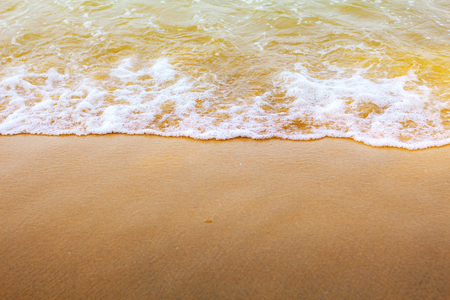 Waves on sand beach at sunrise.の写真素材