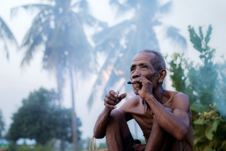 Old man are smoking in the countryside on field.の写真素材