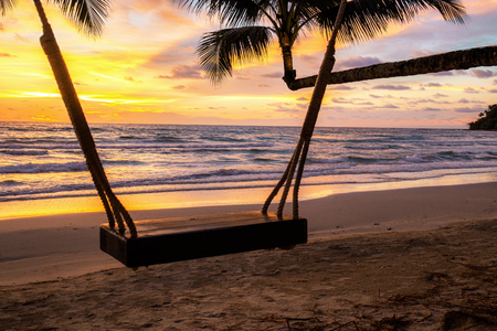 Swing on beach at sea with sunset in the summer.の写真素材