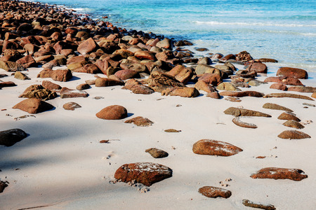 Rocks on sand with sunlight at the sea.の写真素材