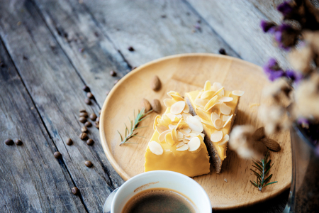 Cake and coffee on wooden tray with table with background.の写真素材