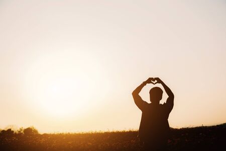 Men in cosmos field with silhouette at sunset.の写真素材