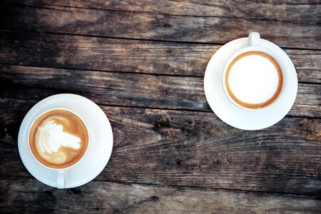Coffee cup of twin on old wood with background.の写真素材