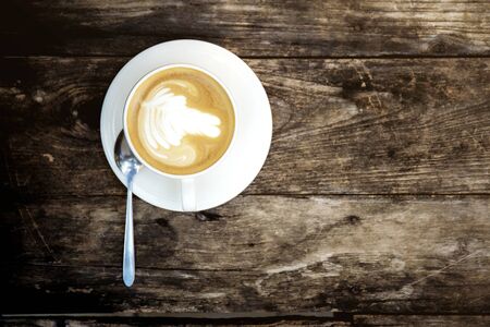 Coffee cup on old wood with background.の写真素材