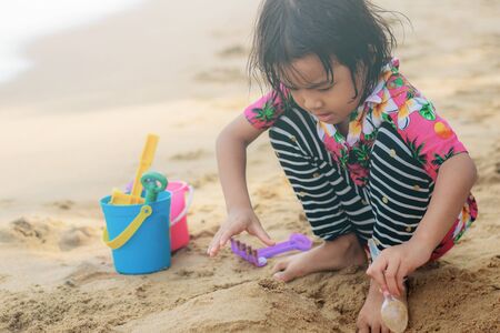 Asian girl are playing a toy on beach.の写真素材