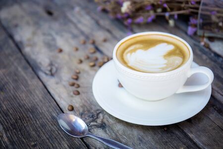 Coffee cup and spoon on wooden table.の写真素材
