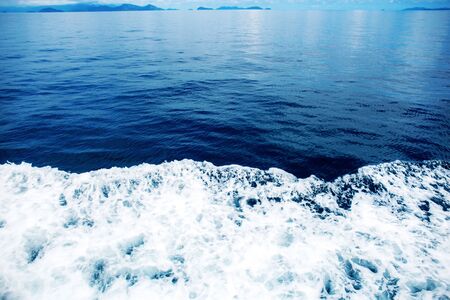 Waves of blue sea at the sunlight with color background.の写真素材