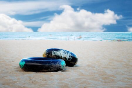 Life ring on sand beach at the sea with blue sky.の写真素材