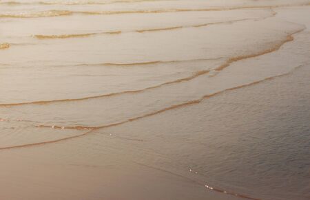 Waves on the beach at sunset.の写真素材