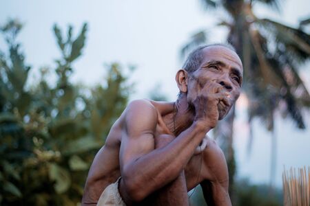 Old man are smoking cigarettes in the countryside.の写真素材