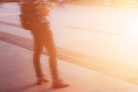 Young man stands in city with the sun shining.の写真素材