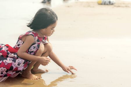 Asian girls are playing on beach at the sea.の写真素材