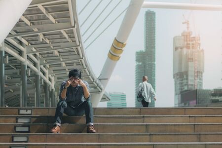 Young man sitting on a stairs in the city.の写真素材