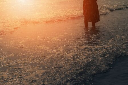 Girl standing at the sea with sunset.