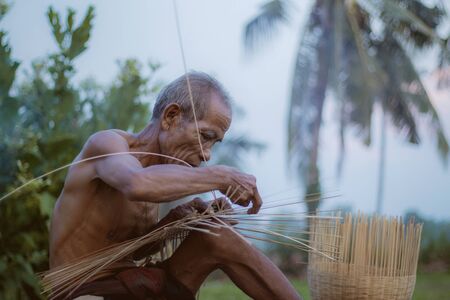 Old man are weaving bamboo on field in the countryside.の写真素材