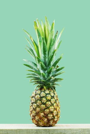 Pineapple on wood with the green background.の写真素材