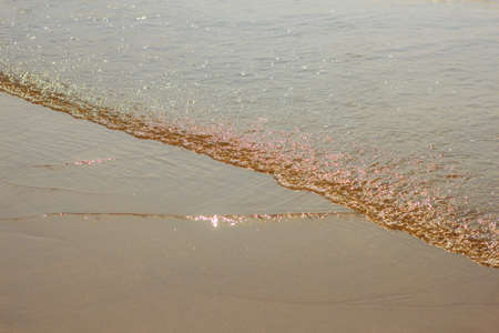 Sea waves on the beach at sunrise.の写真素材