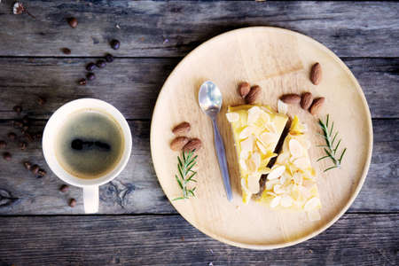 Coffee cup and cake on tray with a wooden background.の写真素材