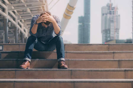 Young man sitting of strain in the city.の写真素材