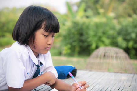 Schoolgirl are homework in the countryside.の写真素材