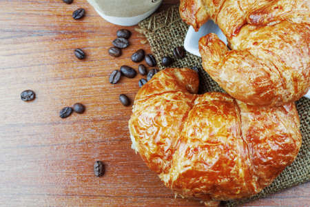 Croissant on plates and coffee on wooden floor.の写真素材
