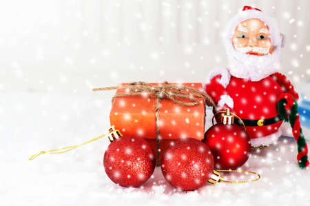 Gift and red balls with snow falling in winter.の写真素材