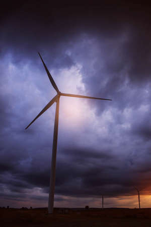 Wind turbines with a dark sky in the eveningの写真素材