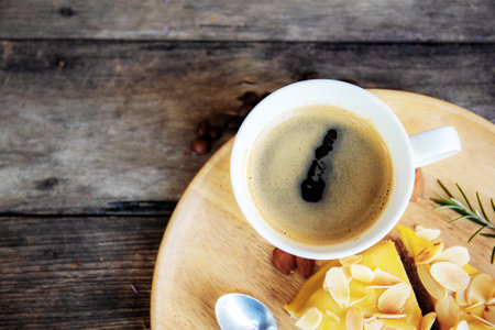 Black coffee and cake on wooden table.の写真素材