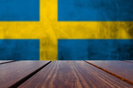 Wood Table Top Background and Grunge flag of Sweden on the concrete wall.の写真素材