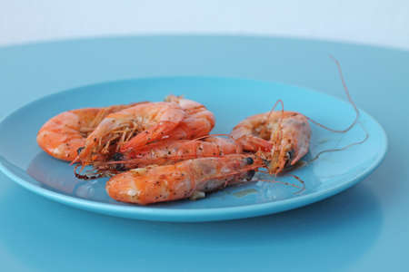 Boiled shrimps on blue plate. Healthy mediteranean sea food.の写真素材