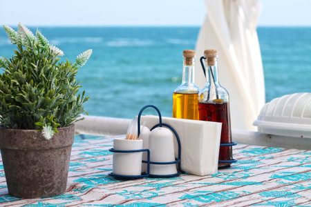 View from open air restaurant overlooking the sea. Olive oil and vinegar bottles on the table with the sea in the background.の写真素材