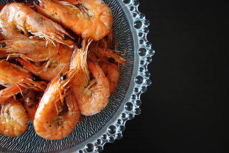 Boiled prawns on a glass plate on a black background.の写真素材