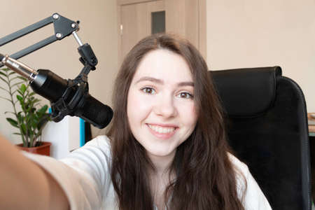 Teen girl blogger influencer talking to camera with followers. Woman making video call at home. Home streaming studio, recording vlog. Webcamera viewの写真素材