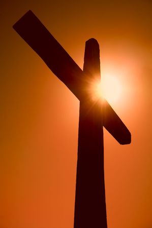 silhouette of the cross against the sun on the skyの写真素材