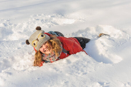 beautiful young girl in funny hat playing in fresh snow