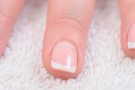 Fingers with french manicure on white towelの写真素材
