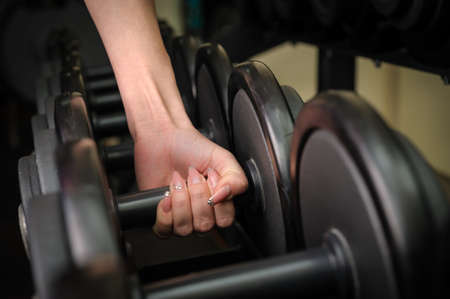 Female hand holding dumbbellの写真素材