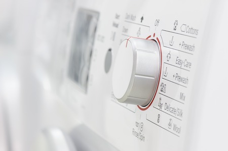 closeup of new white laundry or washing machine, selective focus on control elementsの写真素材
