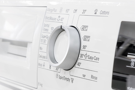 closeup of new white laundry or washing machine, selective focus on control elementsの写真素材