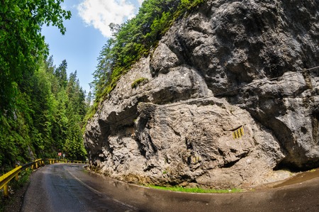 Curved wet road in Bicaz Canyon one of the most exciting travel road in Romania. Sunny after rain.の写真素材