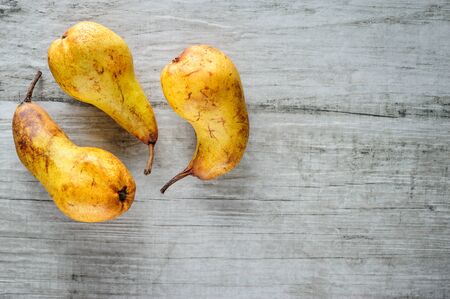 yellow pears on white wooden background, top view.の写真素材
