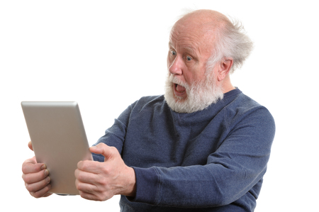 Funny shocked senior man using tablet computer isolated on whiteの写真素材