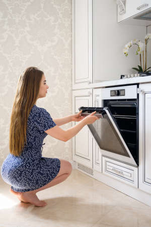 Young woman at luxury modern classic white kitchen interior